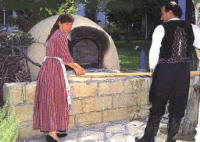  Original bread baking oven tended by a Cypriot couple wearing Cyprus national dress